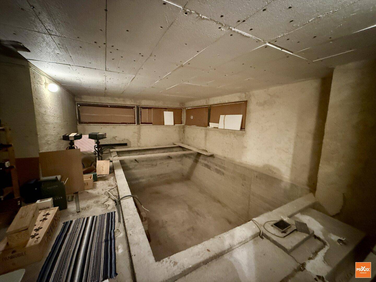 Unfertiger Raum im Untergeschoss mit einer vorbereiteten Grube für einen Innenpool.