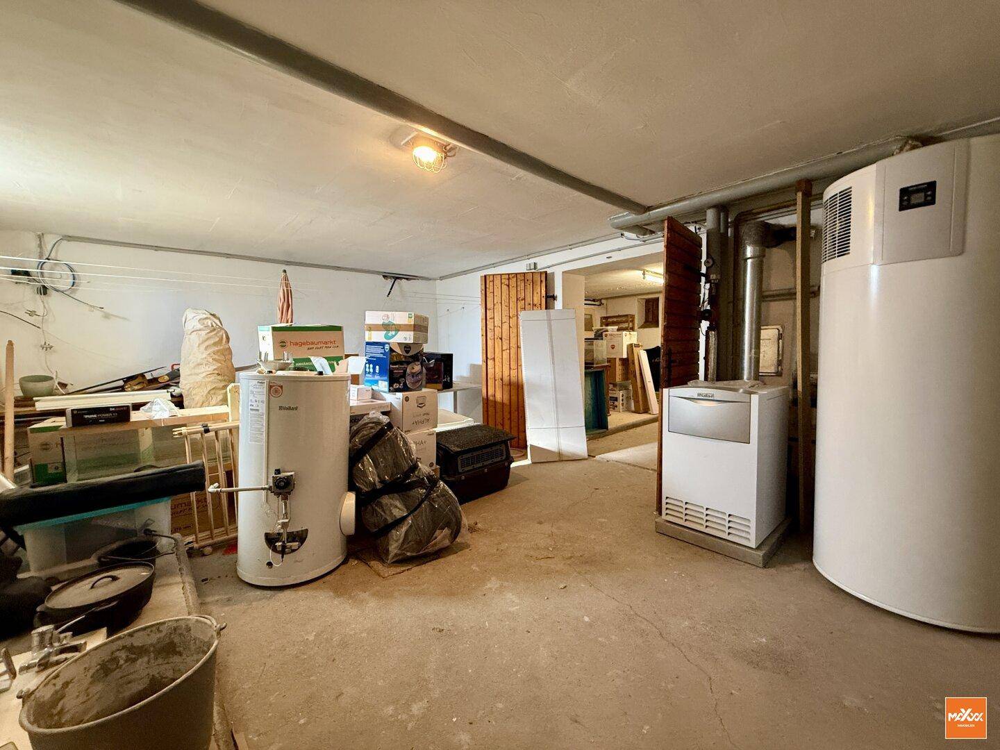 Heizungsraum im Keller mit Warmwasserspeicher und weiteren technischen Installationen.
