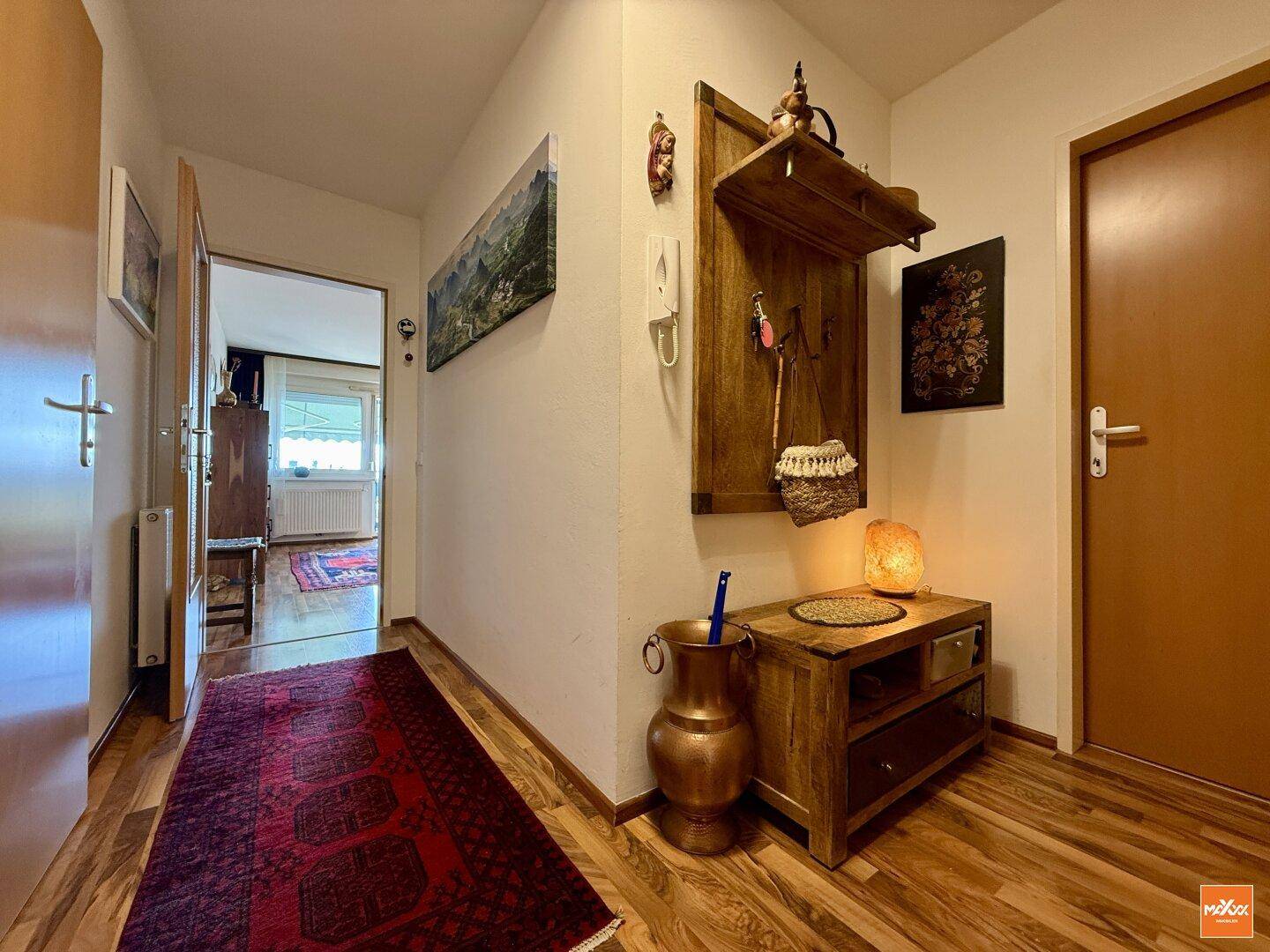 Gemütlicher Eingangsbereich mit Holzboden, Garderobe und traditionellem Teppich.