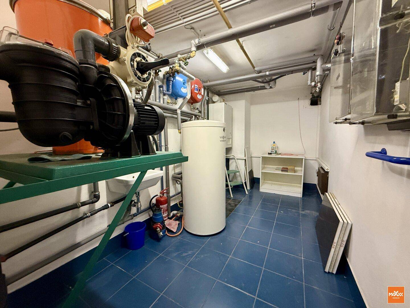 Technikraum mit Heizungsanlage, Rohren und verschiedenen Installationen.
