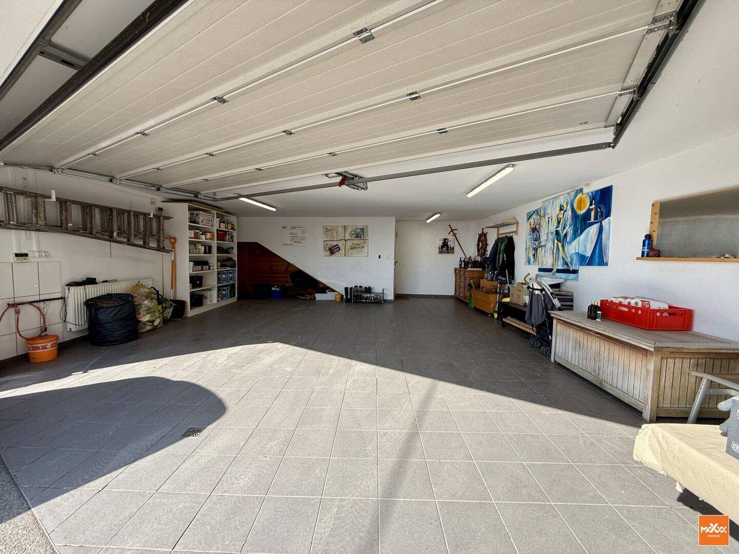 Geräumige Garage mit Fliesenboden und viel Platz für Fahrzeuge und Lagerung.