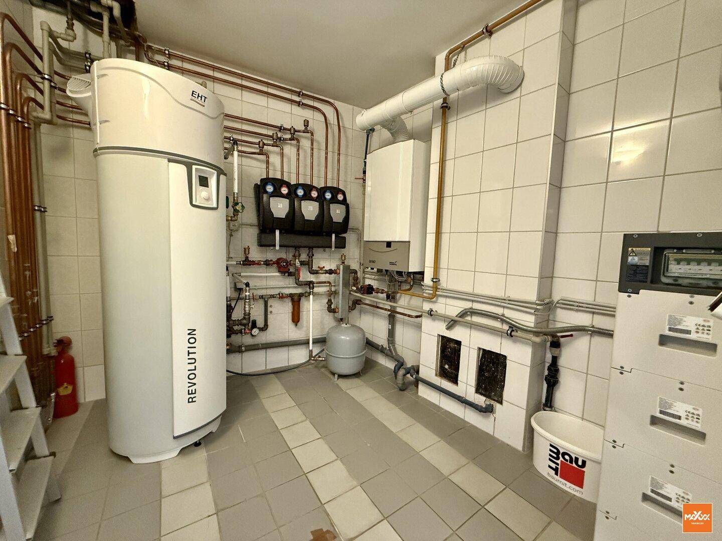 Heizungsraum mit moderner Wärmepumpe und komplexer Rohrinstallation.