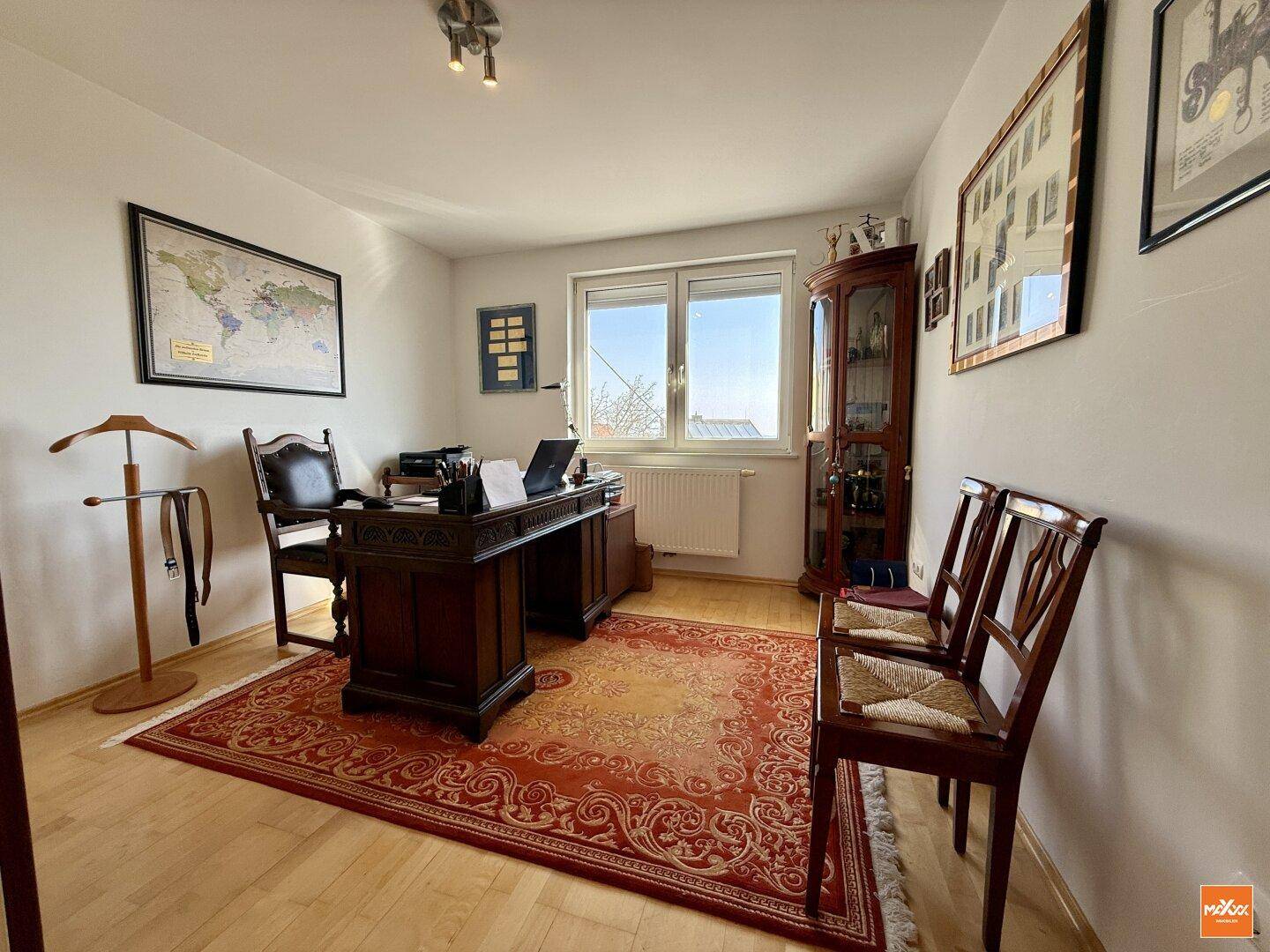 Klassisch eingerichtetes Arbeitszimmer mit Holzboden, Schreibtisch und Teppich.