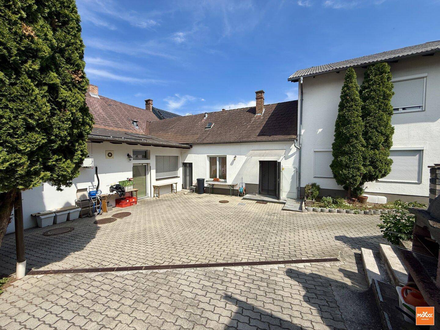 Großer gepflasterter Innenhof zwischen den Gebäudeteilen unter blauem Himmel.