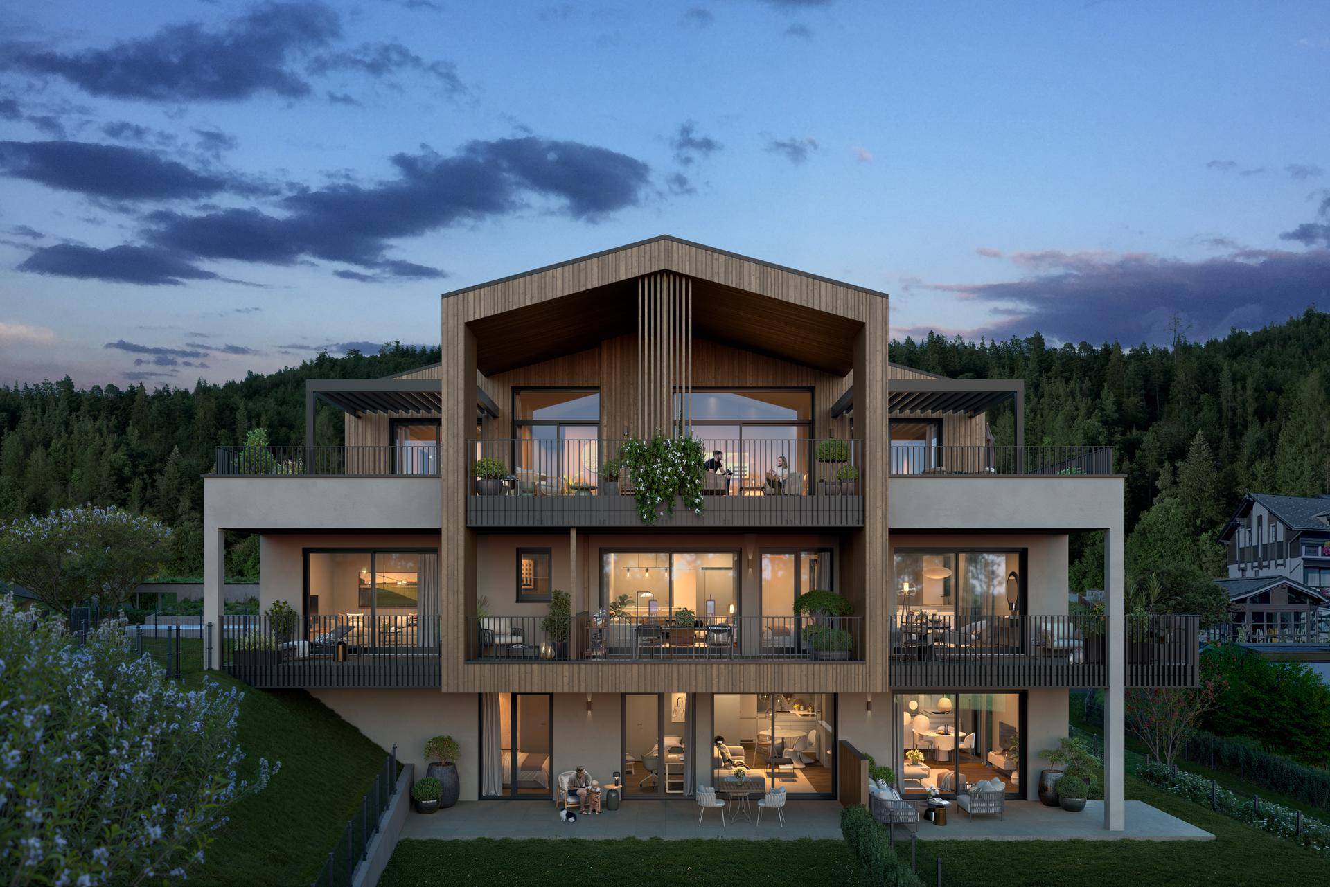 Elegantes Mehrfamilienhaus mit Holzverkleidung, großen Balkonen und Blick auf die umliegende Landschaft.