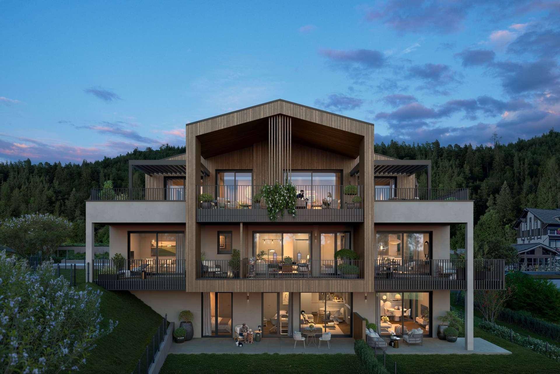 Modernes Mehrfamilienhaus mit Holzverkleidung, großzügigen Balkonen und Terrassen vor bewaldeter Kulisse.