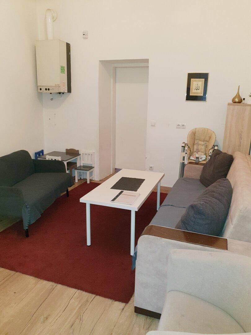 Wohnbereich mit zwei Sofas, einem Couchtisch und einem an der Wand montierten Heizkessel.