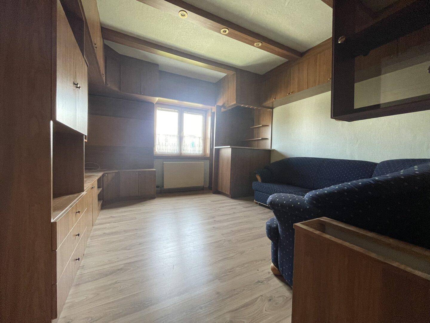 Wohnzimmer mit traditioneller Holzvertäfelung, Einbauschränken und bequemen Sofas.