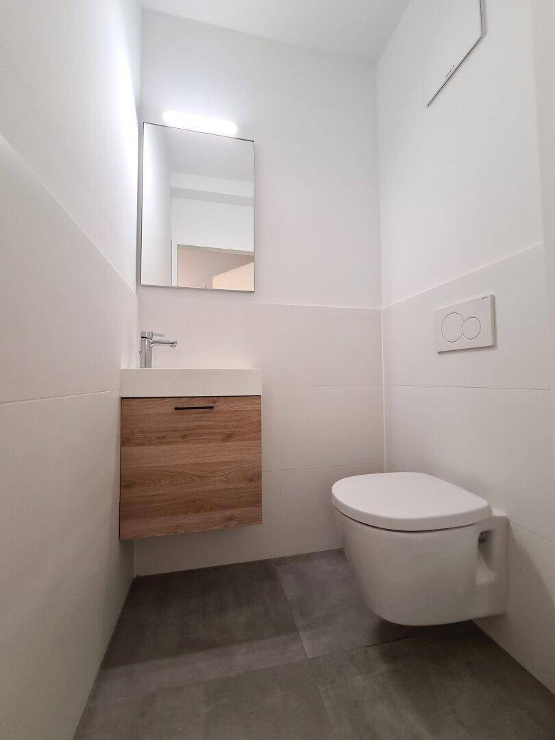 Kleines Gäste-WC mit modernem Waschtisch und wandhängendem WC, minimalistisch gestaltet.