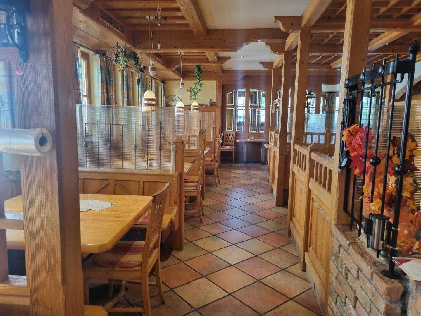 Traditioneller Restaurantbereich mit Holzelementen, Fliesenboden und Trennwänden für Privatsphäre.