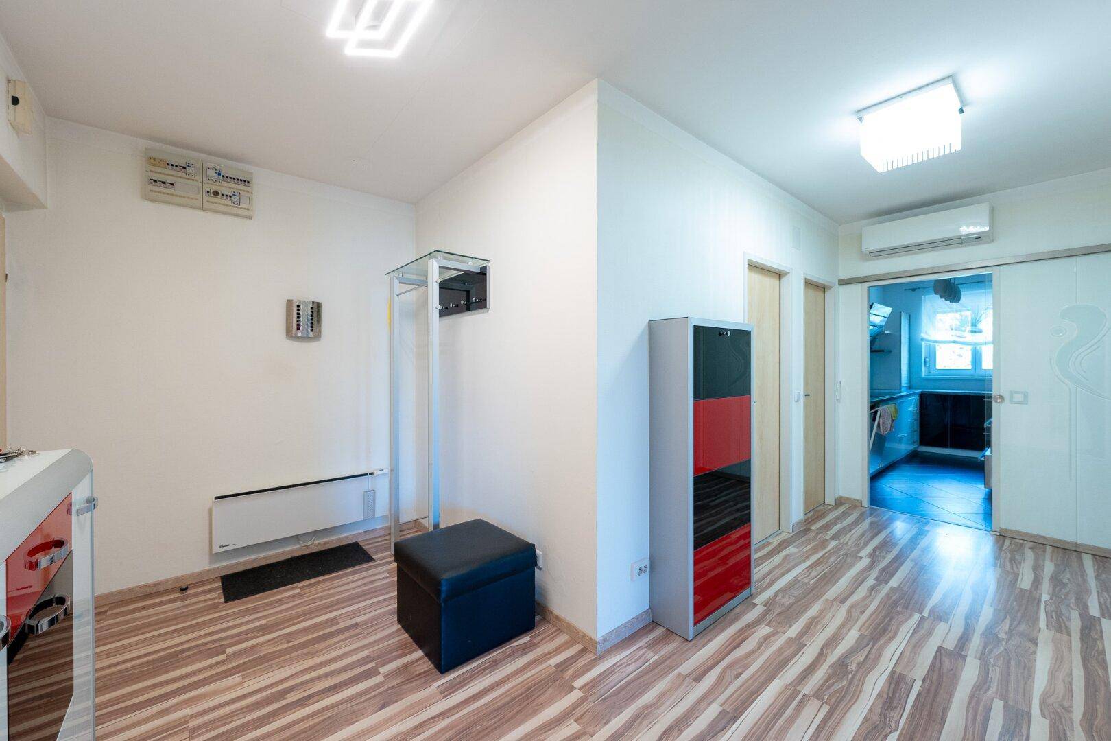 Heller Flur mit Laminatboden, Garderobe und Zugang zu weiteren Räumen.