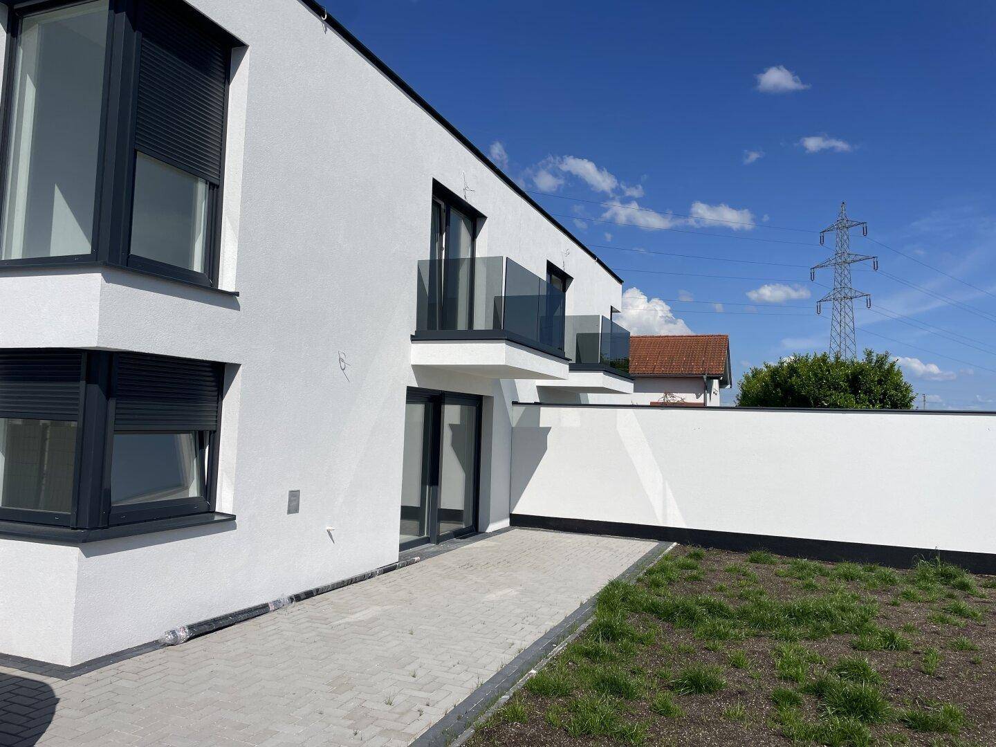 Seitenansicht der Doppelhaushälfte mit Gartenbereich und Blick auf die Umgebung.