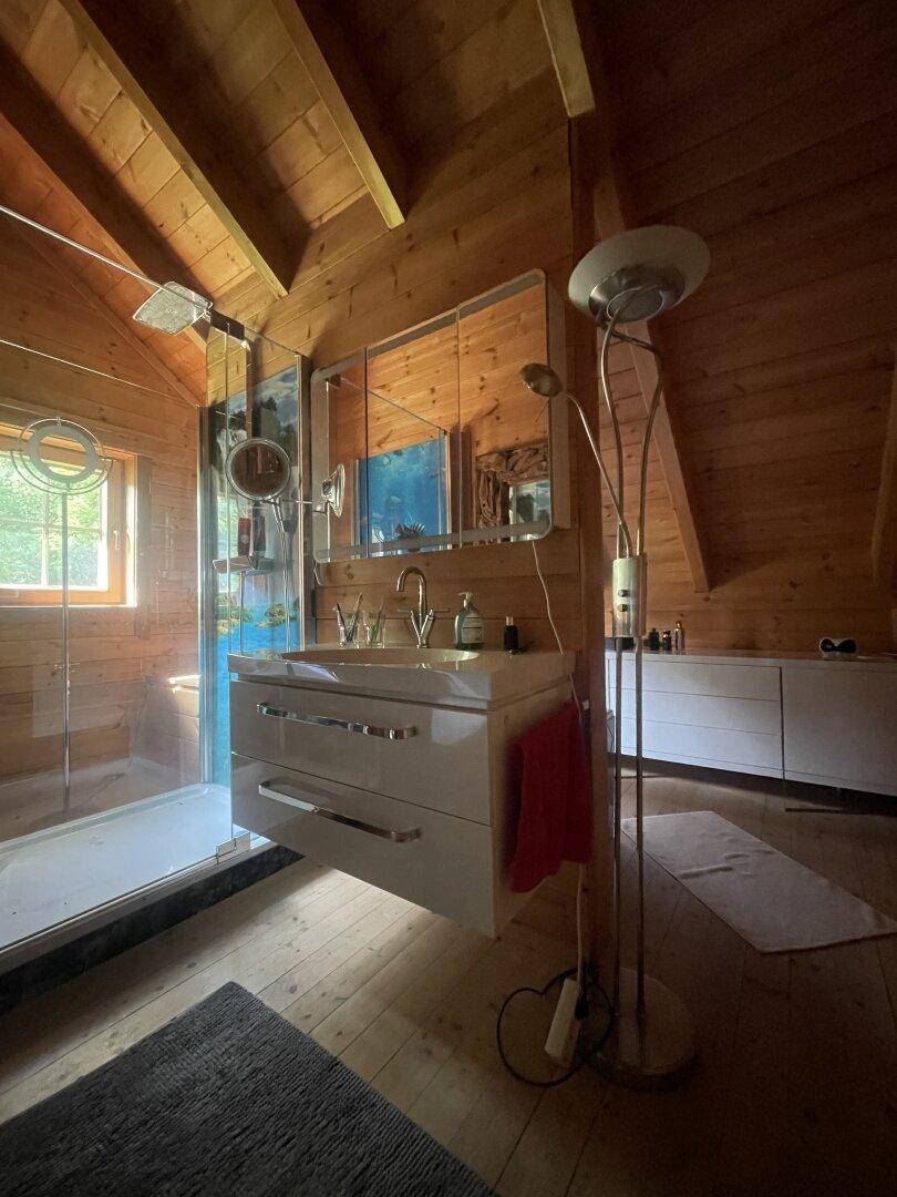 Modernes Badezimmer mit Holztäfelung, Dachschräge, Doppelwaschbecken und einer begehbaren Dusche.