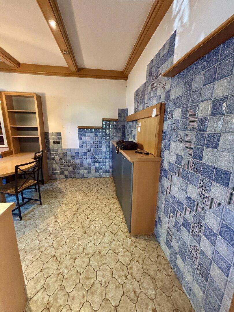 Küchenwand mit auffälligen blauen Fliesen und integrierten Schränken.