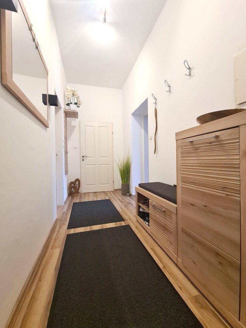 Eingangsbereich mit Garderobe, Spiegel und Schuhschrank, ausgestattet mit Laminatboden.