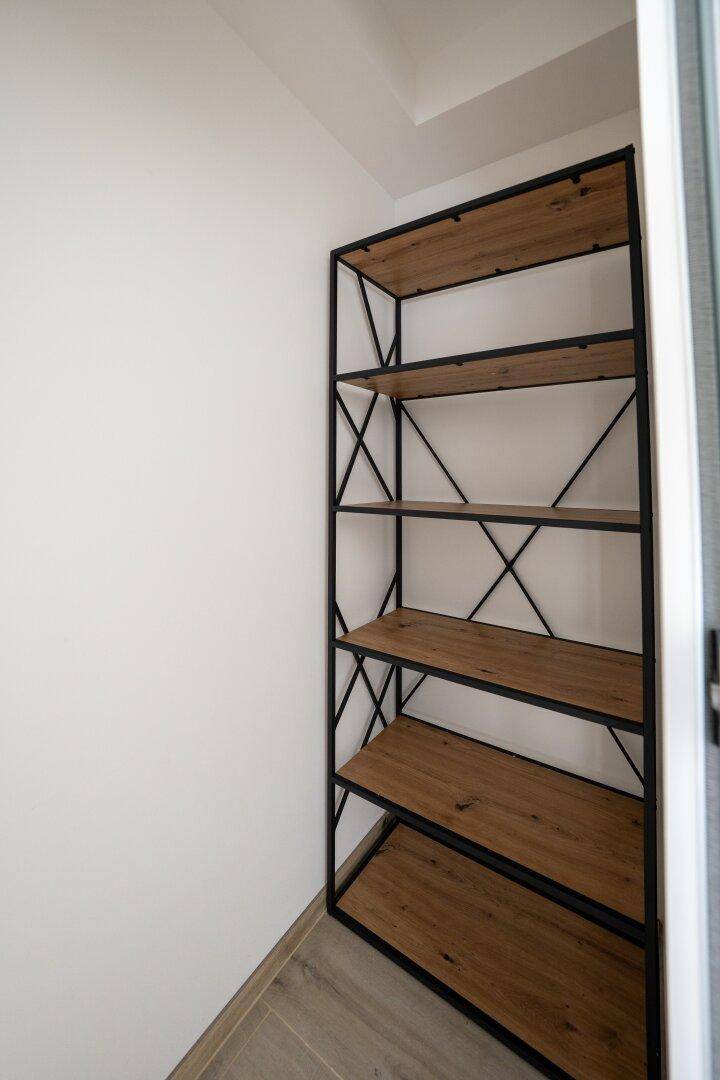 Kleiner Abstellraum mit modernem Regal aus Holz und Metall.