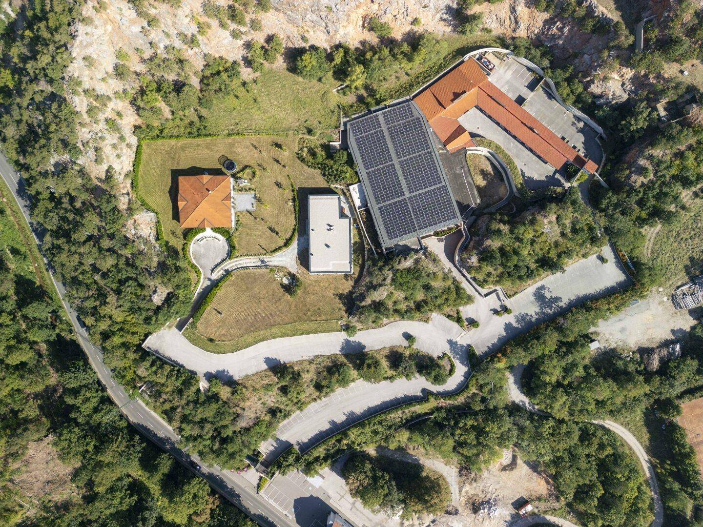 Senkrechte Luftaufnahme des Anwesens mit Gebäuden, Straßen und Solaranlagen auf den Dächern.