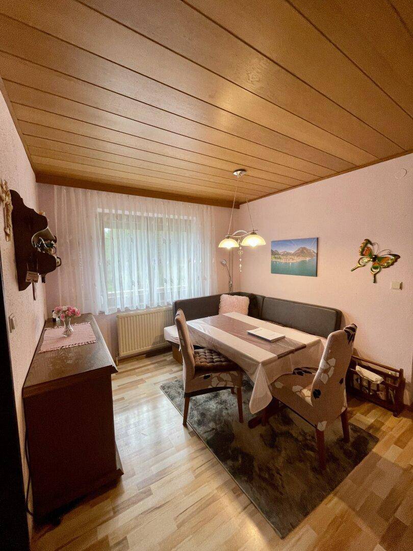 Gemütlicher Essbereich mit Holztäfelung an der Decke und traditionellen Möbeln.