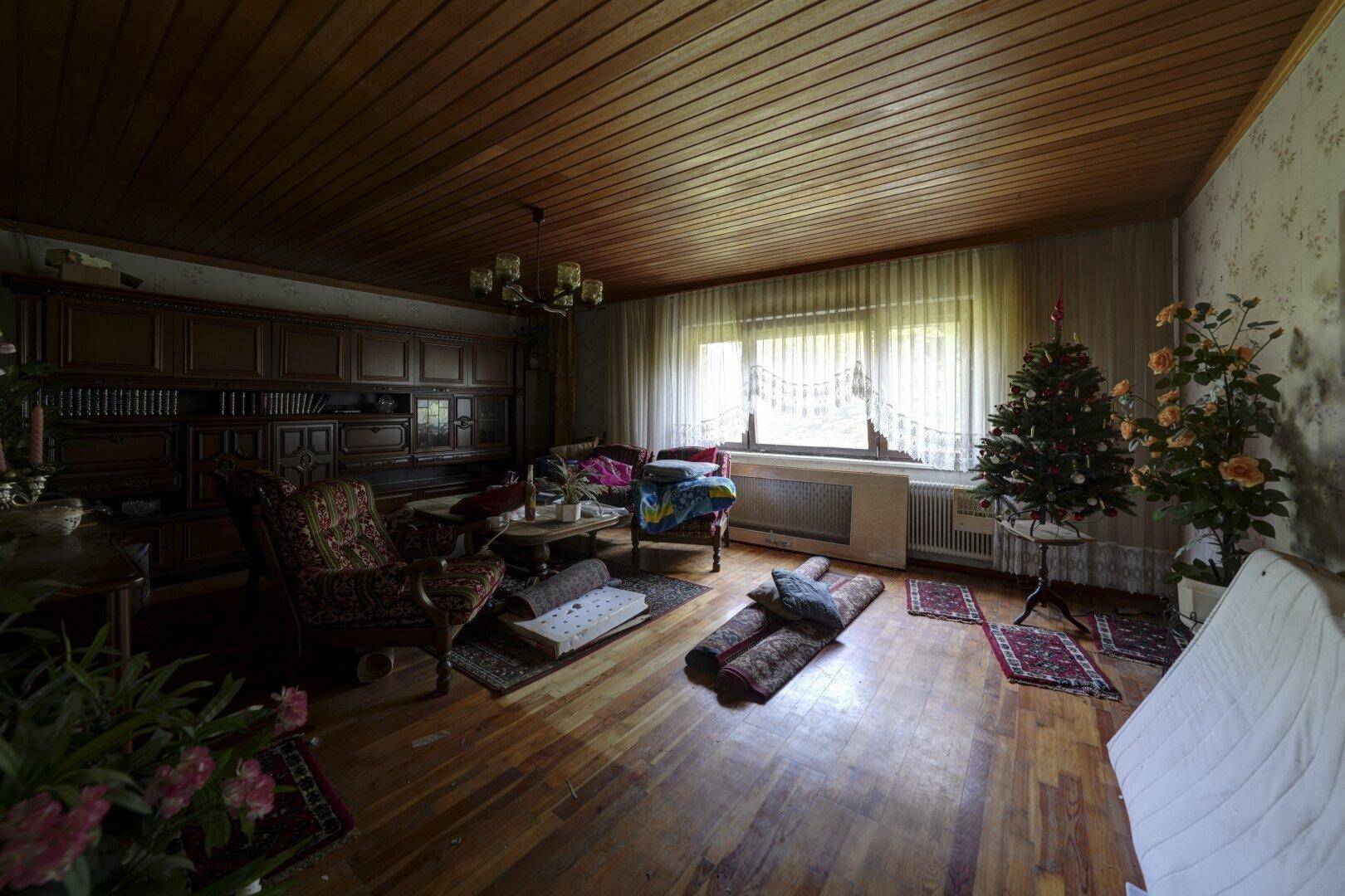 Traditionelles Wohnzimmer mit Holzdeckenverkleidung, Parkettboden und klassischer Einrichtung.