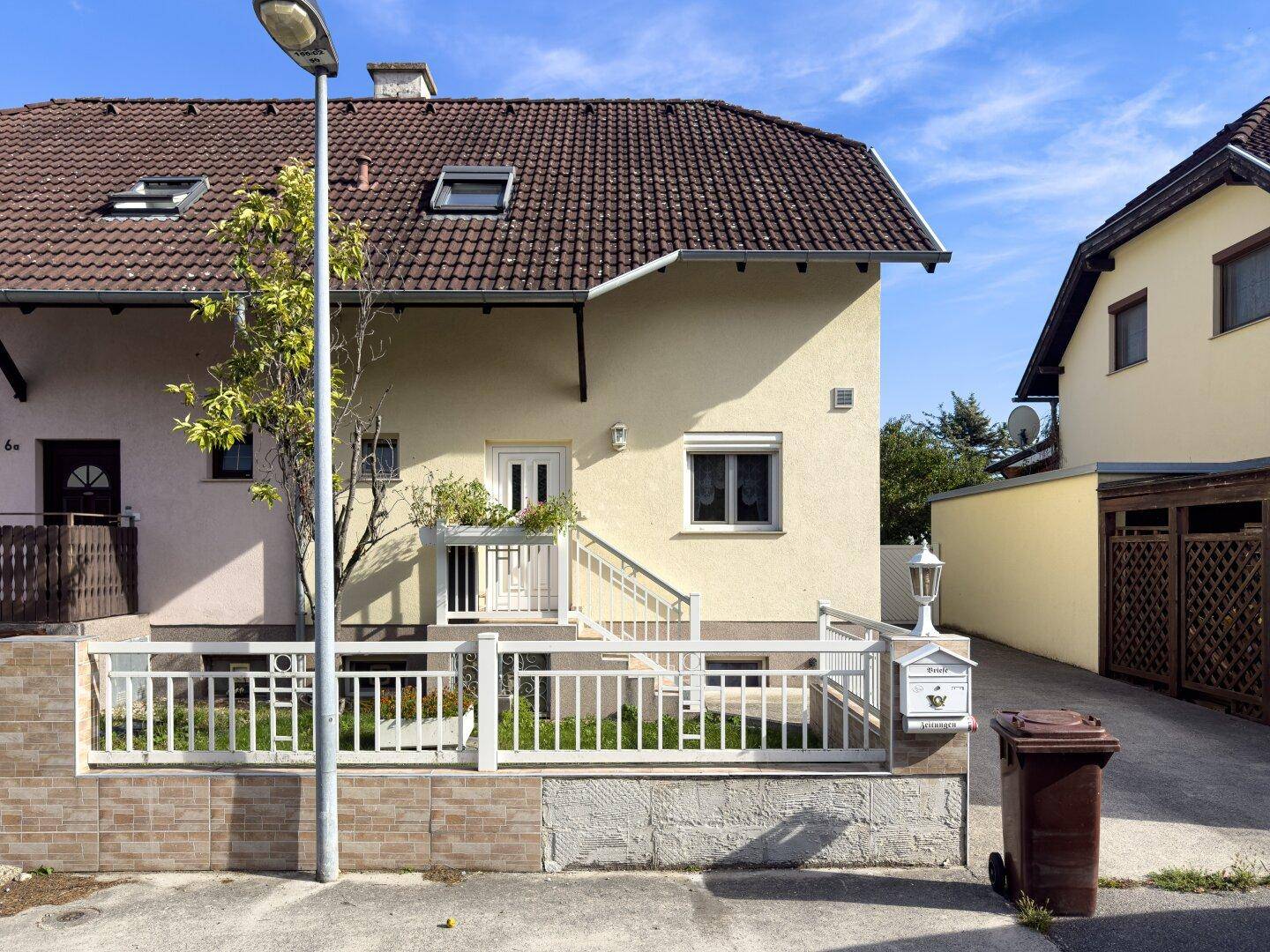 Vorderansicht eines Einfamilienhauses mit Vorgarten und Eingangsbereich.