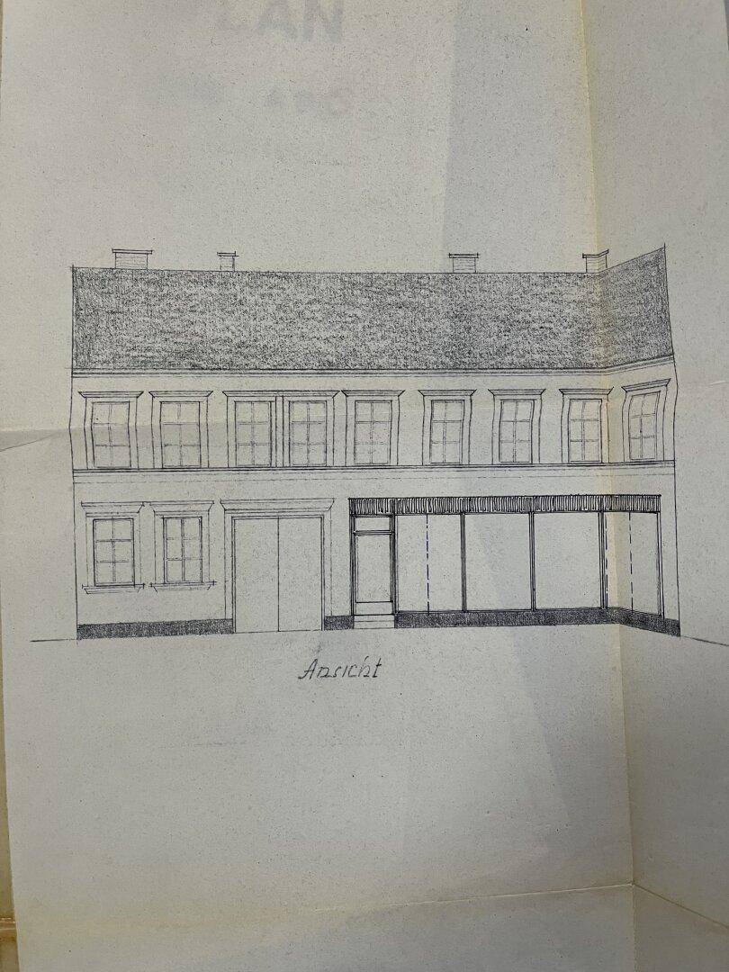 Handgezeichnete architektonische Ansicht der Gebäudefassade mit Fenstern und Garagentor.
