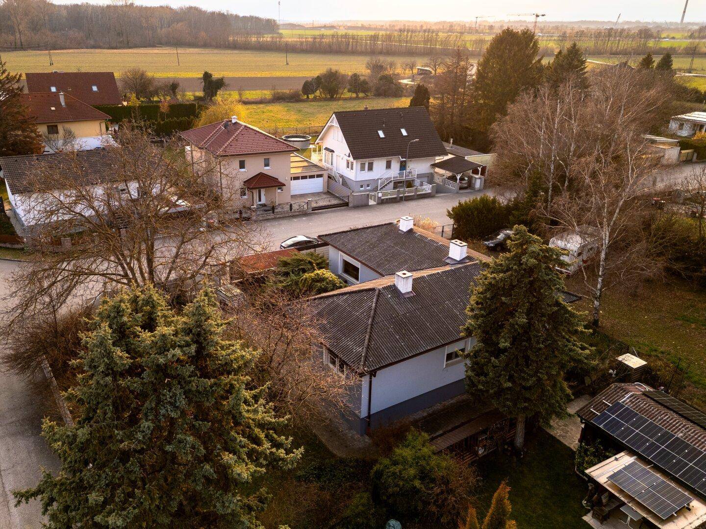 Luftaufnahme eines Einfamilienhauses mit Garten und umliegender Wohnbebauung in ländlicher Umgebung.