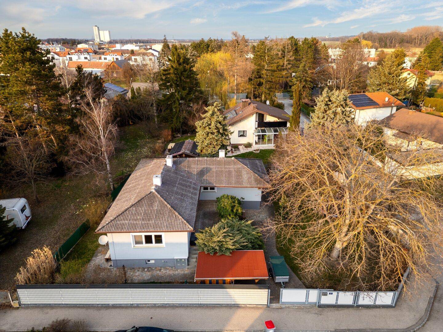 Luftaufnahme eines Einfamilienhauses mit Garten und umliegender Wohnbebauung in ländlicher Umgebung.