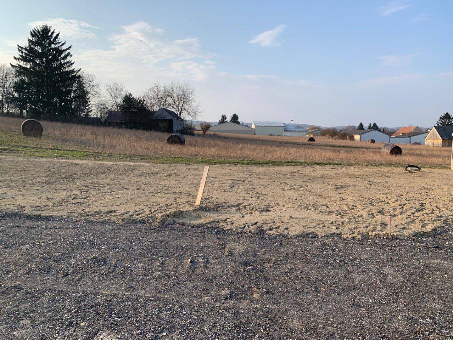 Weitläufiges Grundstück mit Blick auf die ländliche Umgebung und landwirtschaftliche Gebäude.