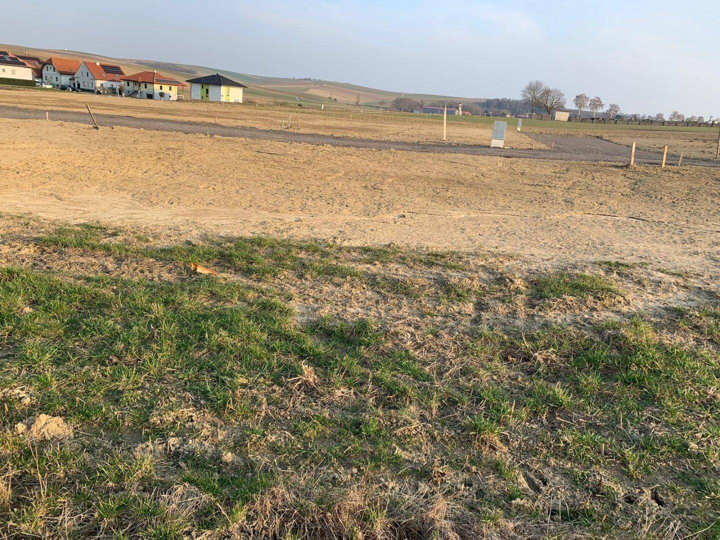 Großes Grundstück in ländlicher Lage mit Blick auf nahegelegene Häuser und weite Felder.