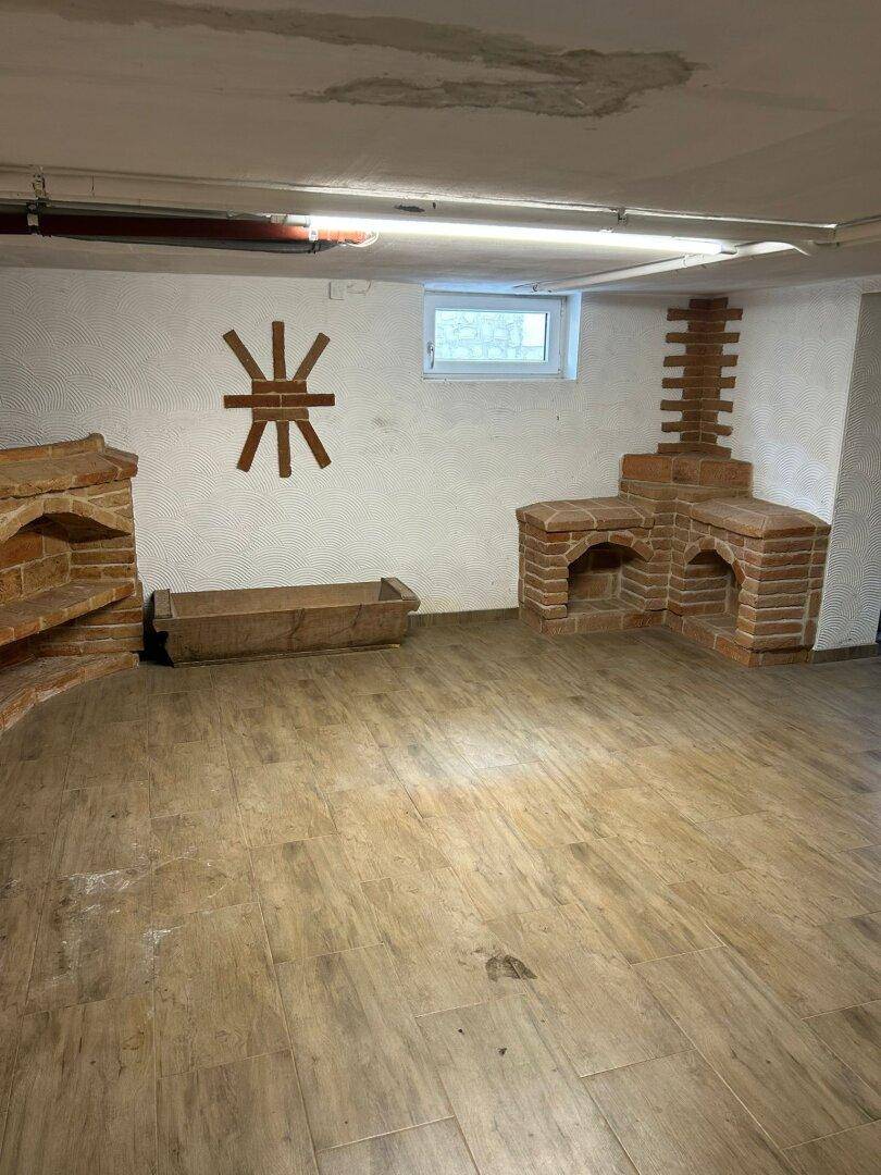 Heller Kellerraum mit Ziegelstein-Dekorationen, Fenster und Fliesenboden.