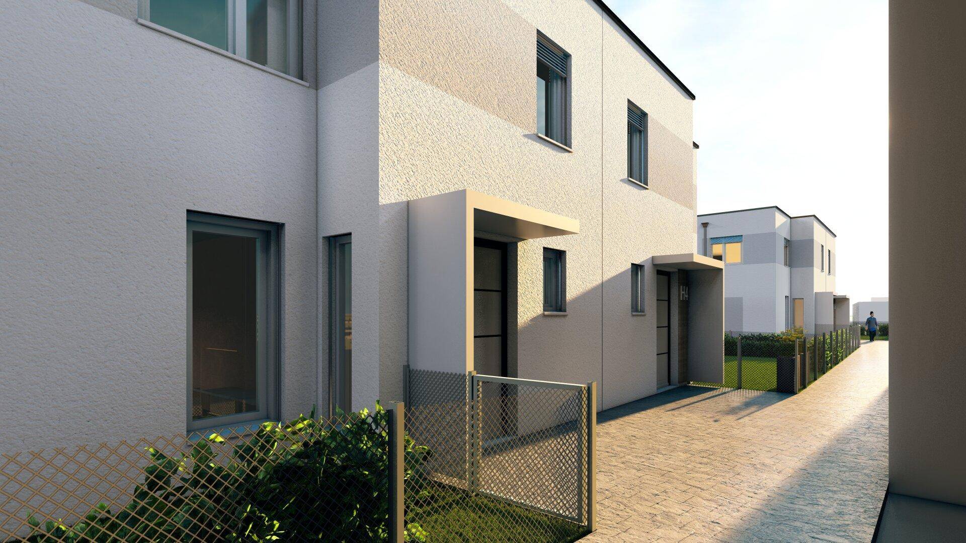 Moderne Reihenhäuser mit schlichter Fassade und kleinen Vorgärten in einer Wohnsiedlung.