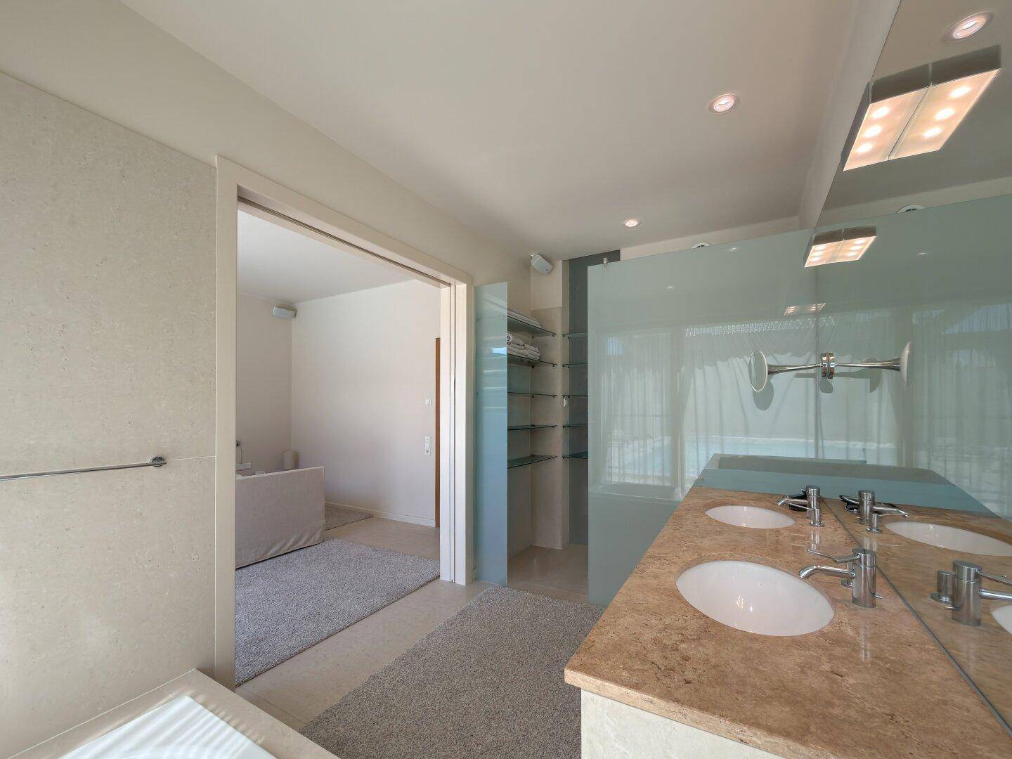 Modernes Badezimmer mit Doppelwaschbecken, großer Spiegelfläche und begehbarer Dusche.