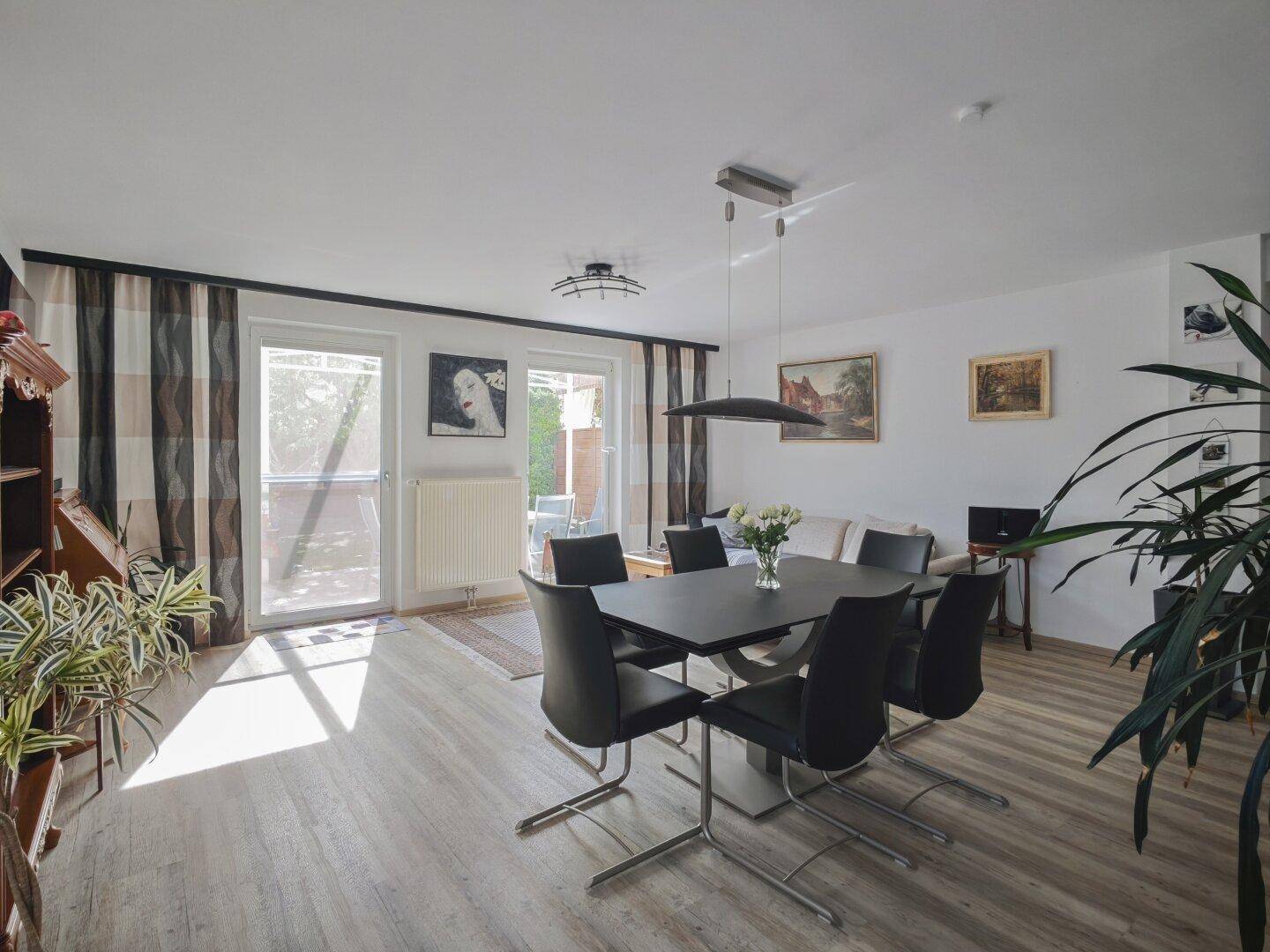 Lichtdurchfluteter Wohn- und Essbereich mit Zugang zur Terrasse und hellem Laminatboden.