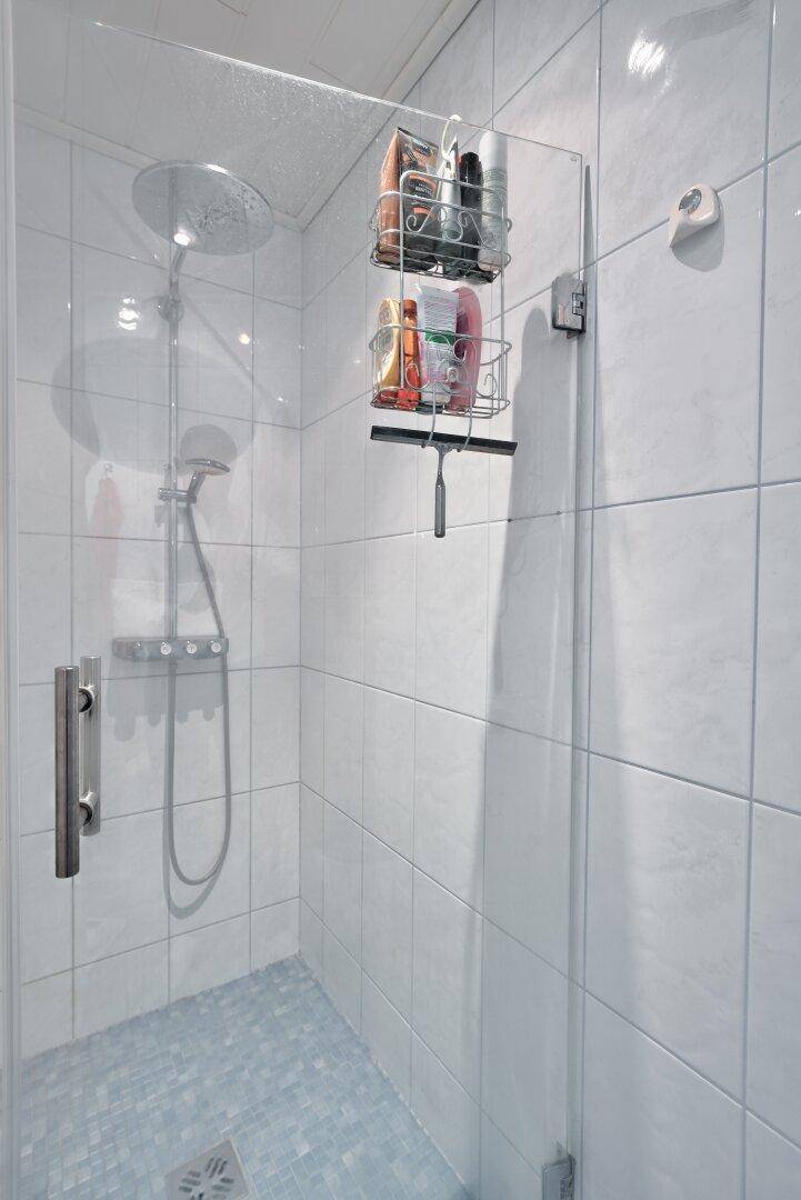 Moderne Duschkabine mit Glaswand und Fliesenboden im Badezimmer.