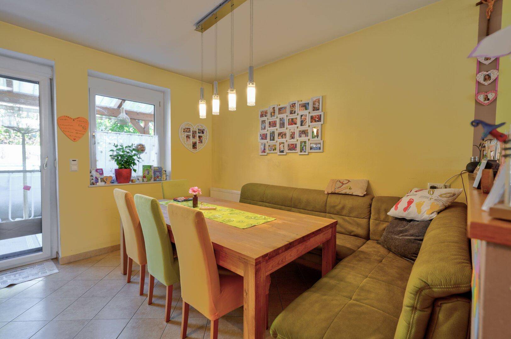 Heller Essbereich mit Holztisch, Eckbank und Zugang zur Terrasse.