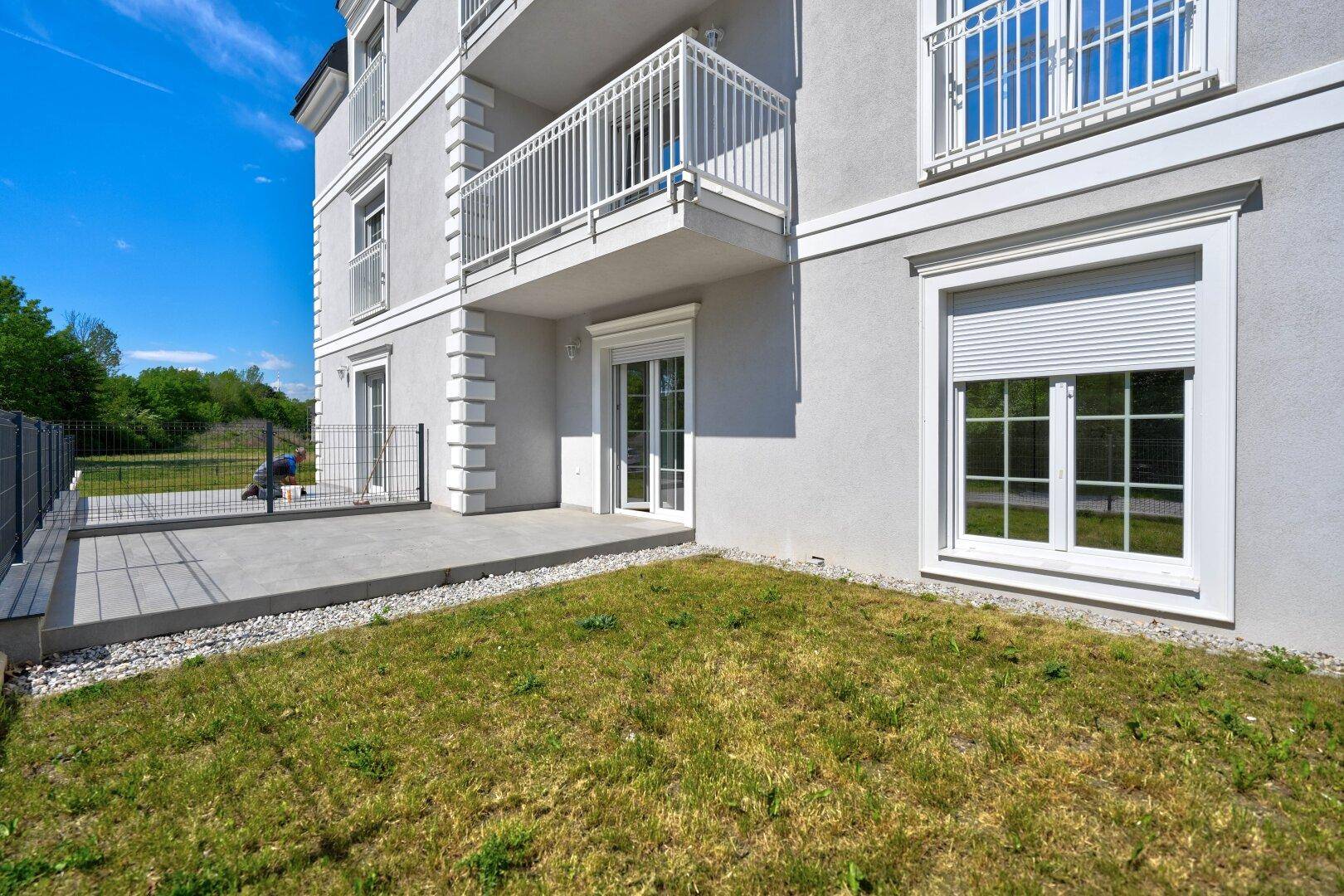 Große Terrasse im Erdgeschoss mit angrenzendem Rasen und Blick auf die Umgebung.