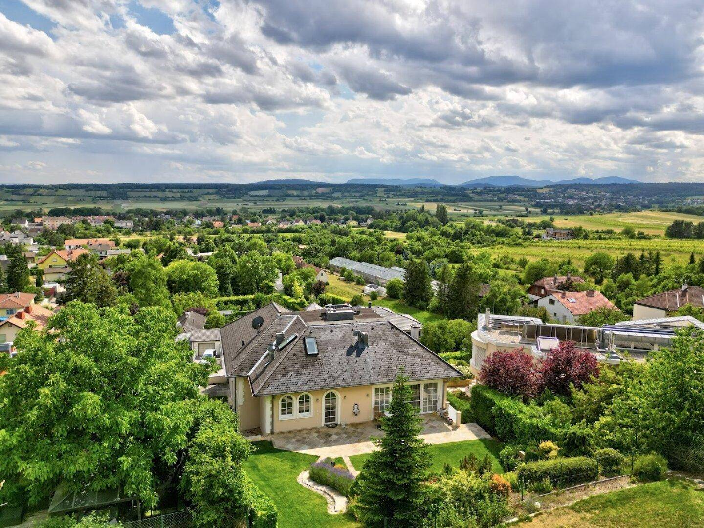 Charmantes Anwesen mit weitläufigem Garten und Terrasse, eingebettet in eine grüne Landschaft mit Fernblick.
