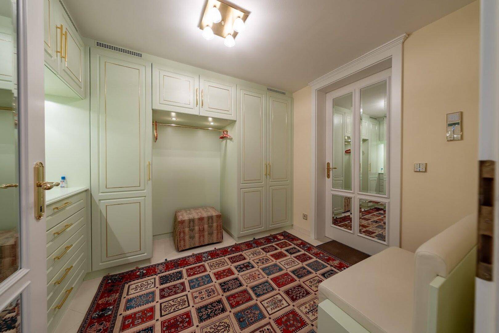 Praktischer begehbarer Kleiderschrank mit maßgefertigten Schränken und Stauraum in hellem Design.