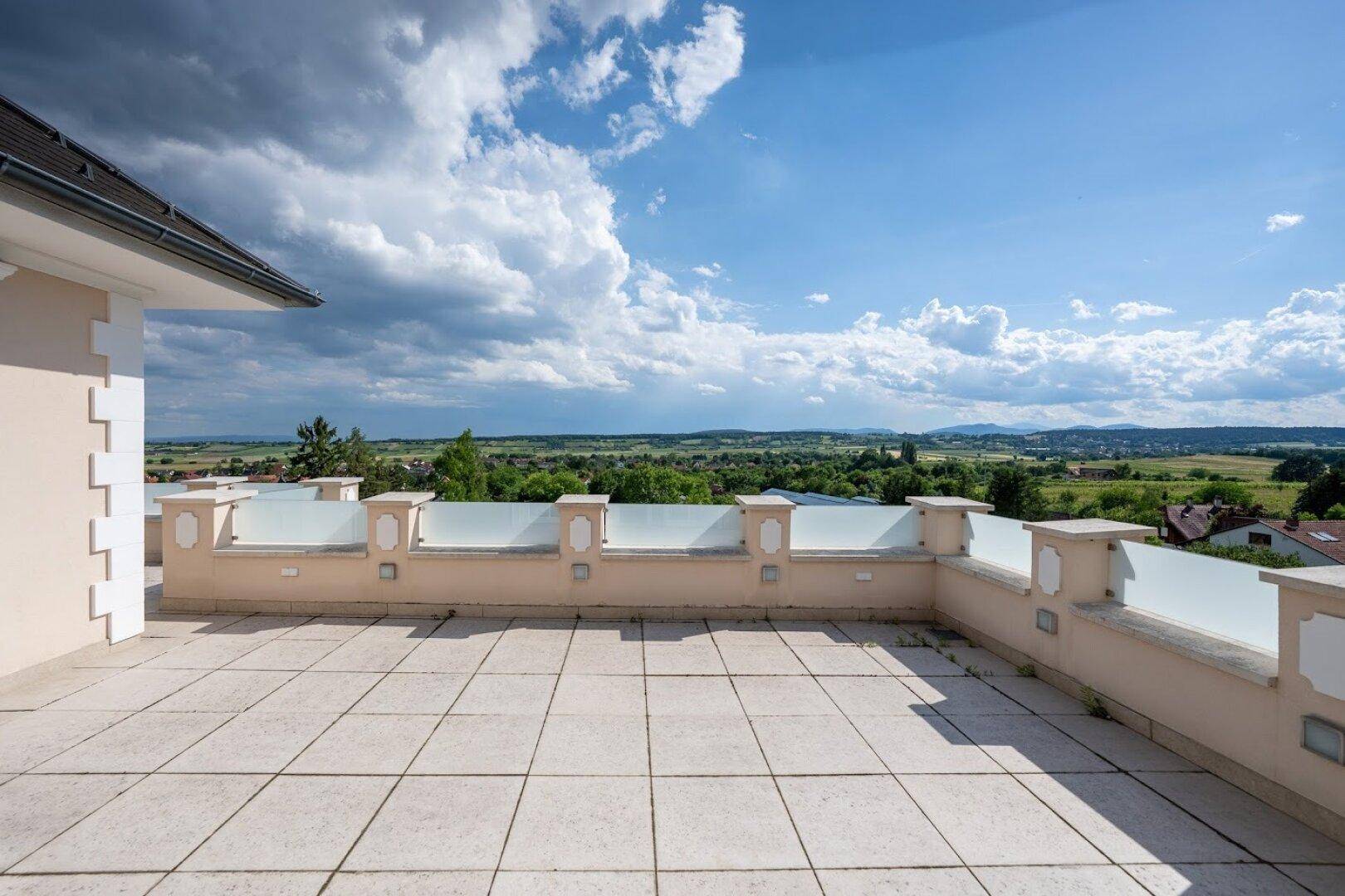 Weitläufige Dachterrasse mit Panoramablick über die umliegende Landschaft und viel Platz zum Entspannen.