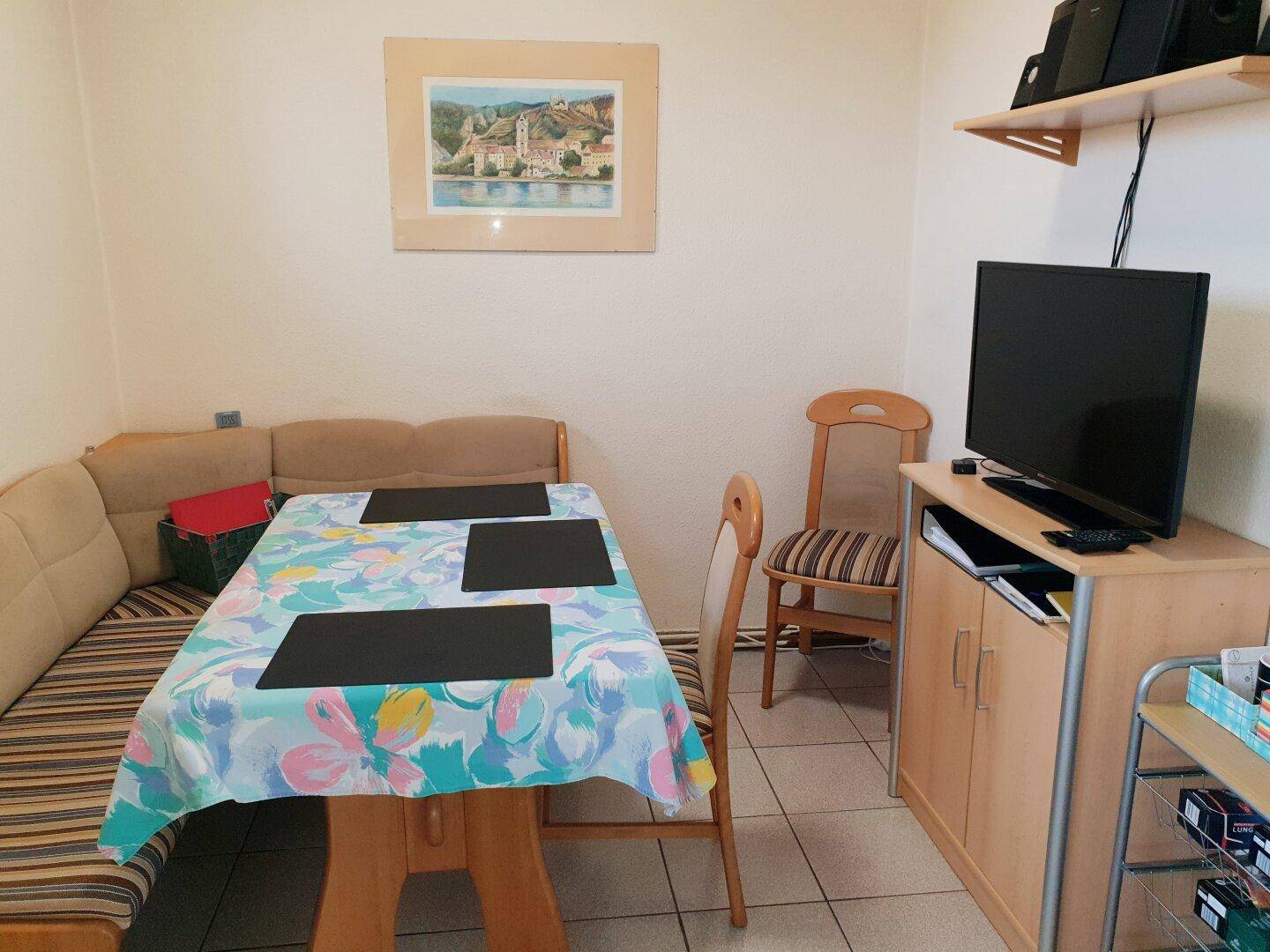 Gemütliche Essecke mit Holztisch, Sitzbank und Stühlen, ideal für Familienmahlzeiten.