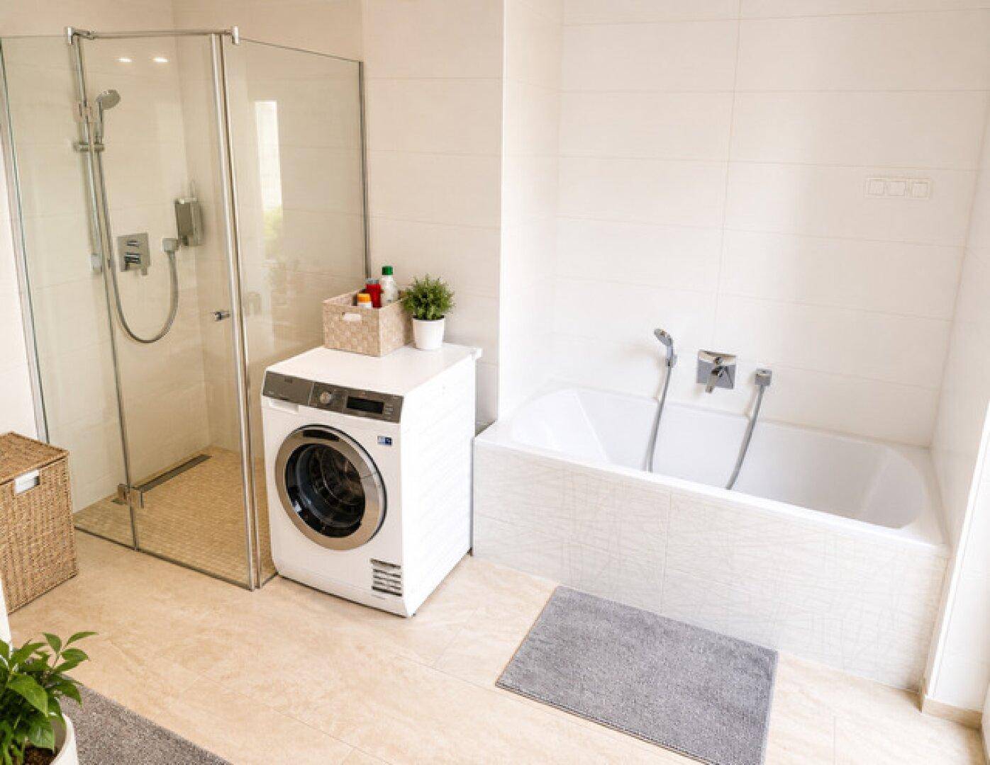 Modernes Badezimmer mit Badewanne, ebenerdiger Dusche und integrierter Waschmaschine.
