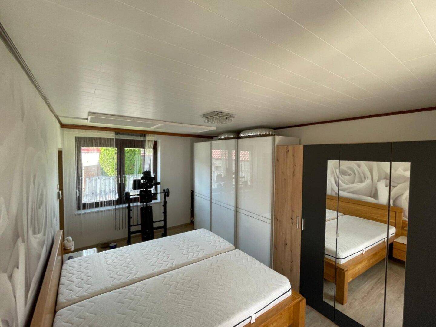Schlafzimmer mit zwei Einzelbetten, großen Kleiderschränken und Blick nach draußen.