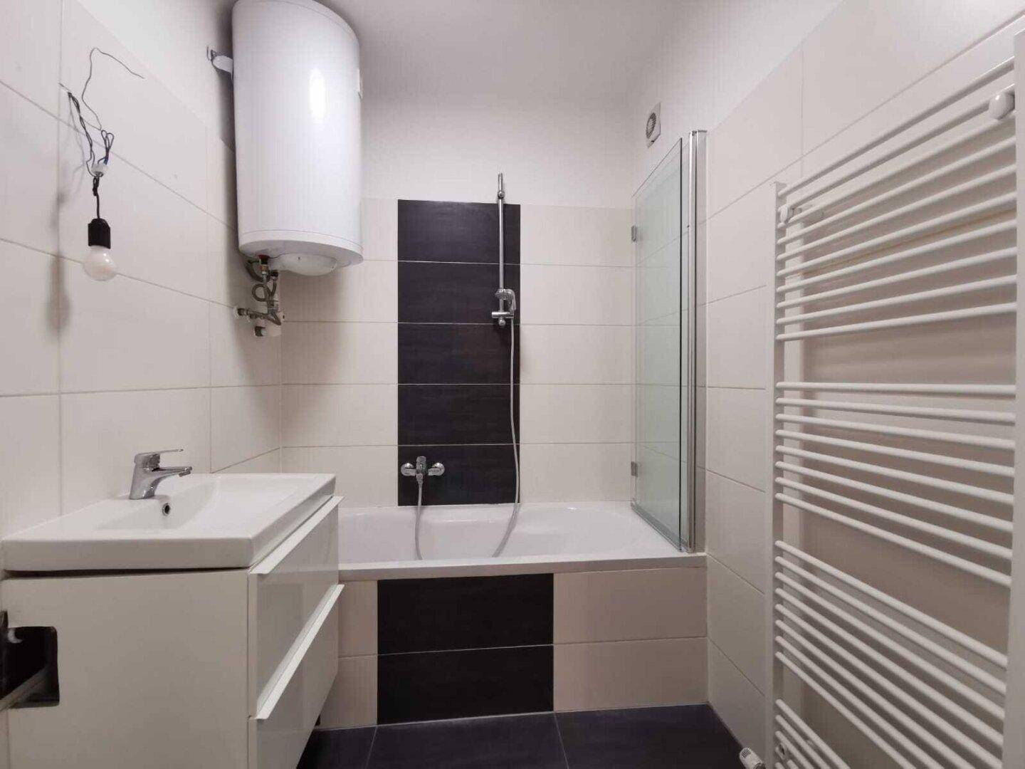 Modernes Badezimmer mit Badewanne, Dusche, Waschbecken und Handtuchheizkörper.
