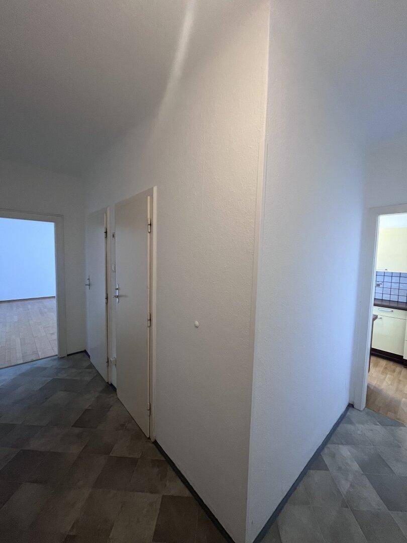 Heller Flur mit mehreren Türen, der zu den verschiedenen Räumen der Wohnung führt.