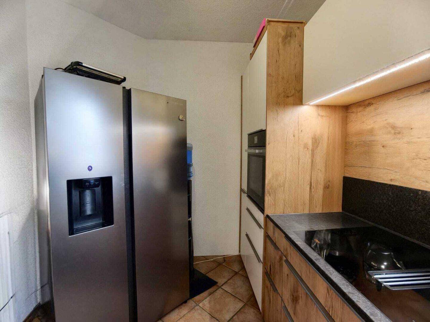 Geräumige Küche mit großem Side-by-Side-Kühlschrank und modernen Einbaugeräten.