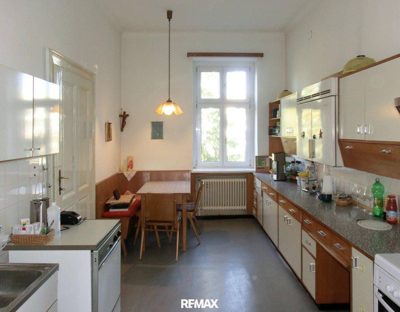 Geräumige Wohnküche mit Essbereich, Einbauküche und Fenster mit Blick ins Grüne.