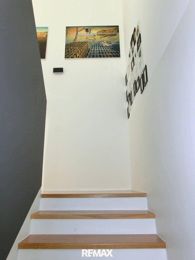 Treppenaufgang mit Holzstufen und moderner Wandgestaltung.
