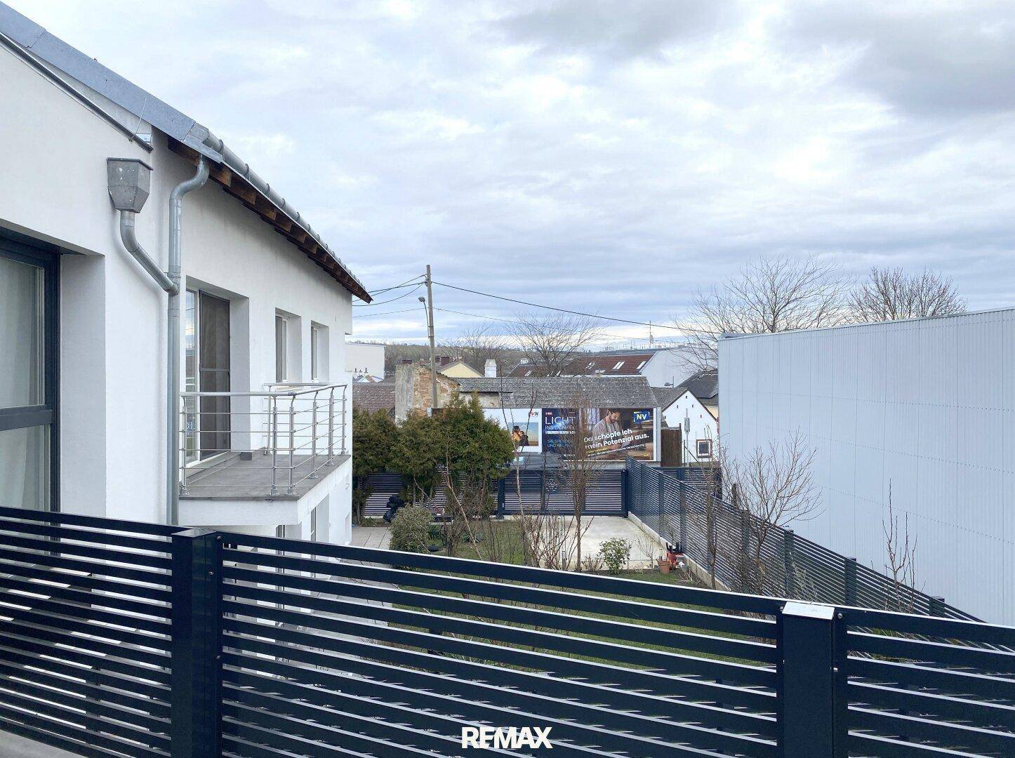 Blick von einem Balkon auf die Nachbarschaft und umliegende Gebäude.