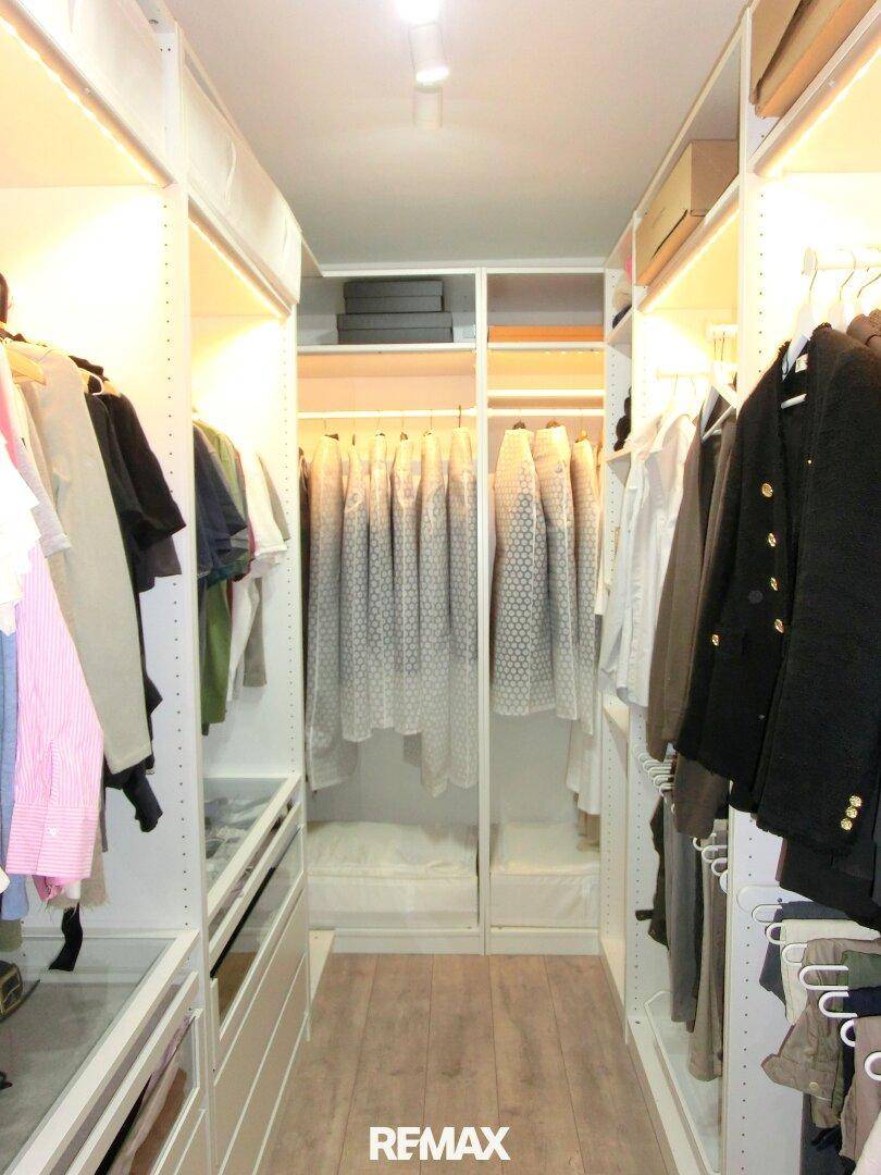 Geräumiger begehbarer Kleiderschrank mit integrierter Beleuchtung.