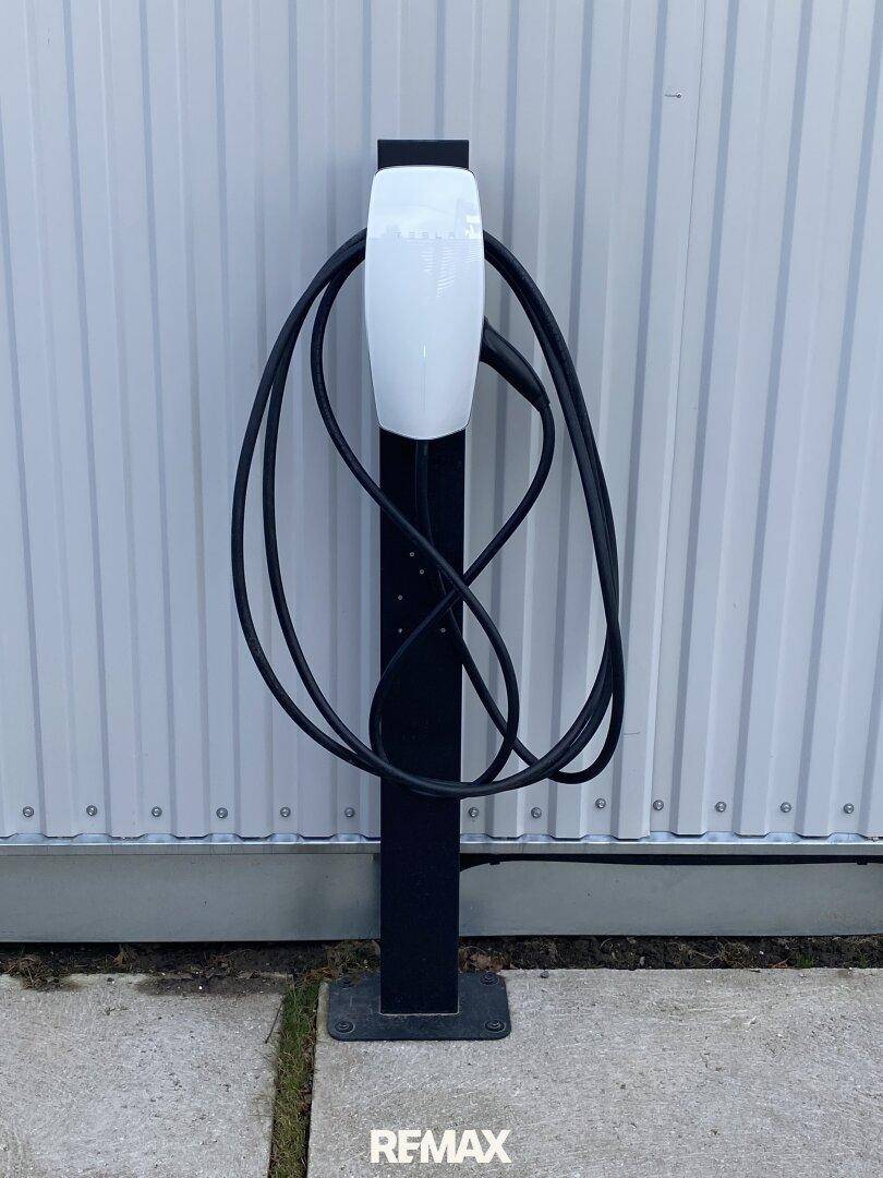 Eine moderne Ladestation für Elektrofahrzeuge an der Außenwand des Gebäudes.